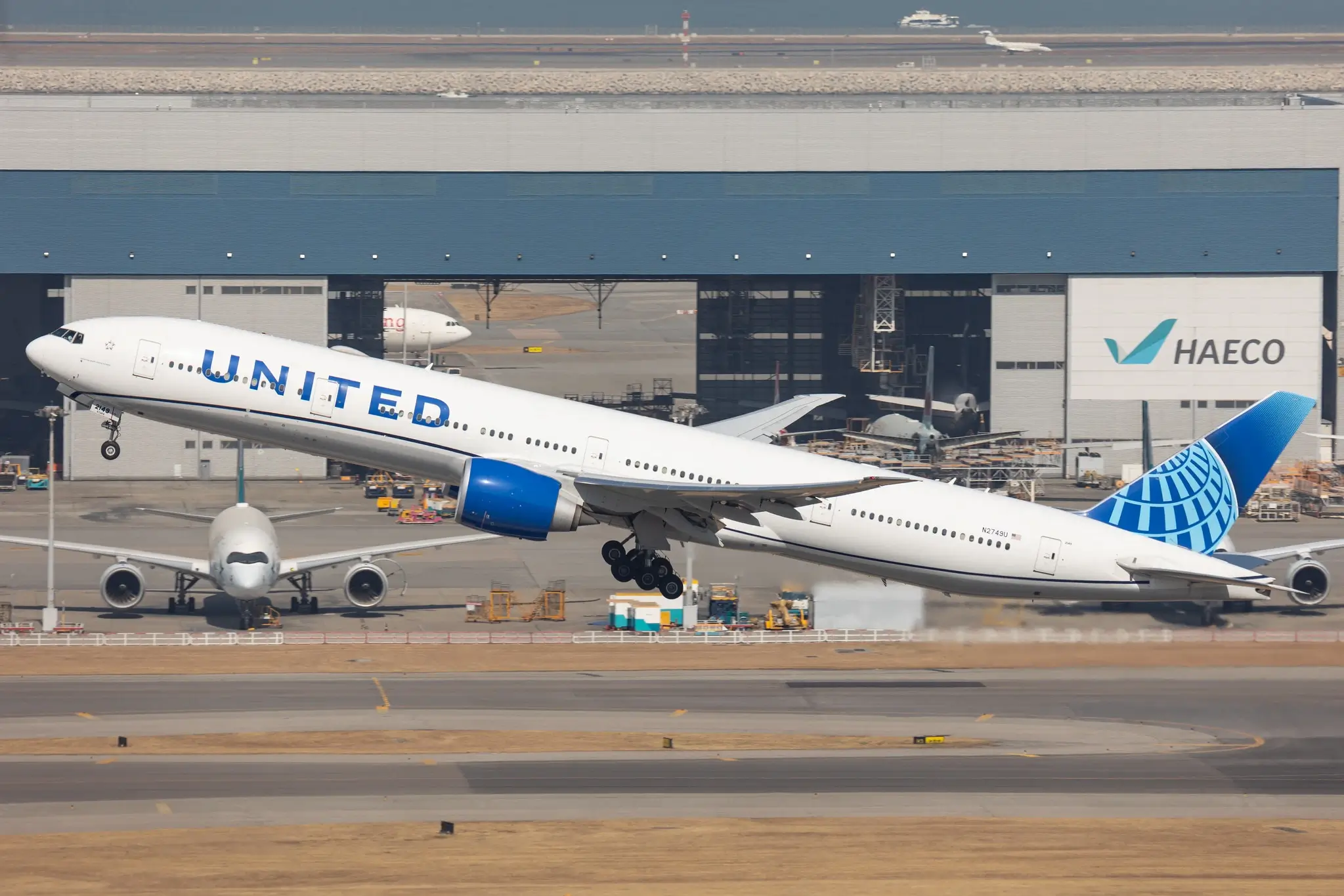 A United Airlines Boeing 777-300ER departs Hong Kong