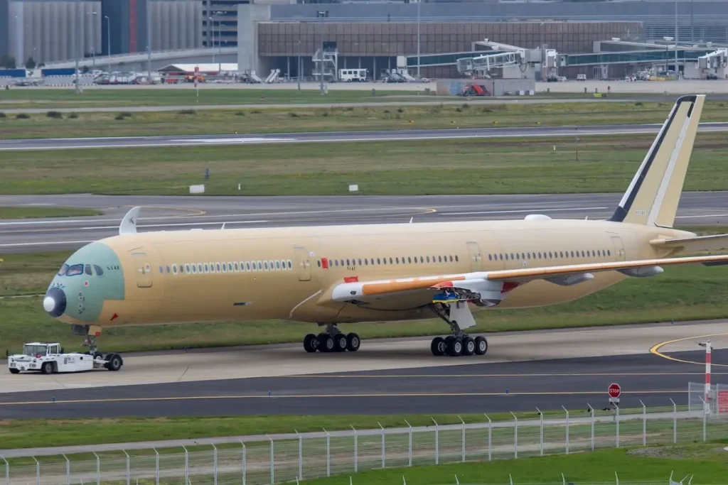Passenger plane Airbus A350 XWB (A350-1000) without coloring. Aircraft being towed by a tractor.