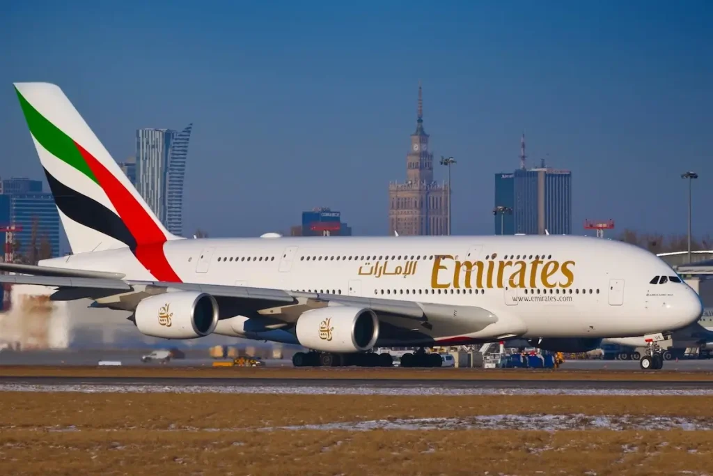 Airbus A380 Emirates taking off from Warsaw Airport against city skyline - 10.02.2017.