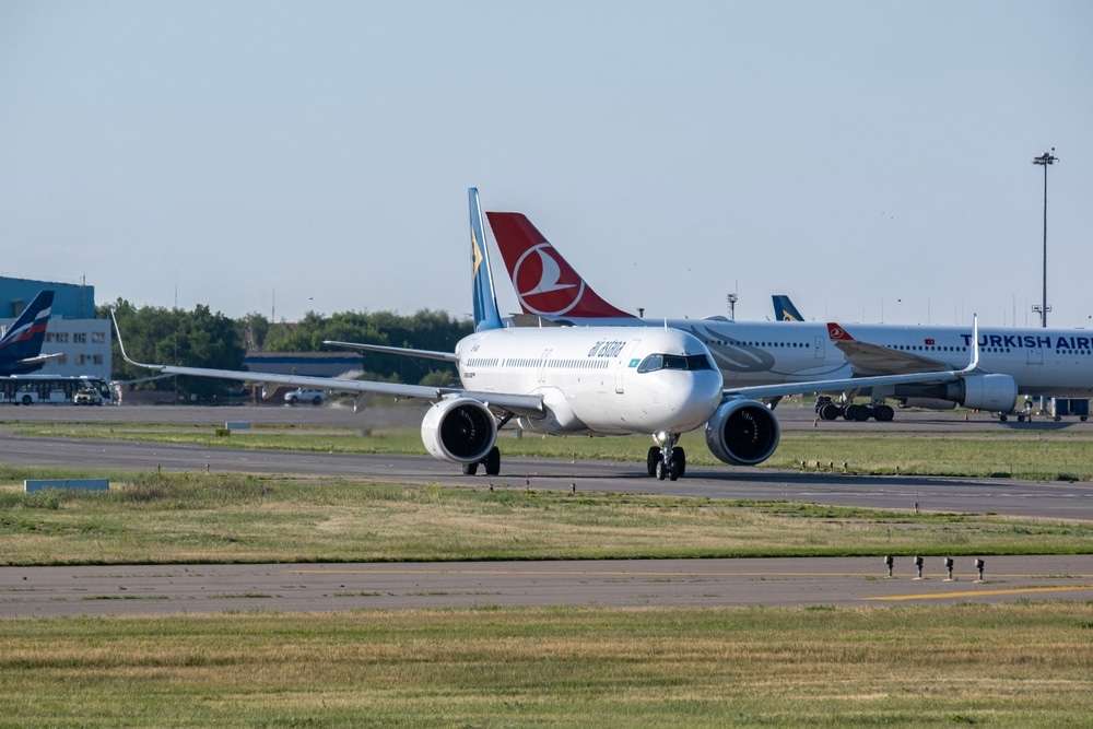 ALMATY, KAZAKHSTAN - May 29, 2025: Side view of an Airbus 321neo aircraft of Air Astana approaching the runway at Almaty Airport. Departure flight
