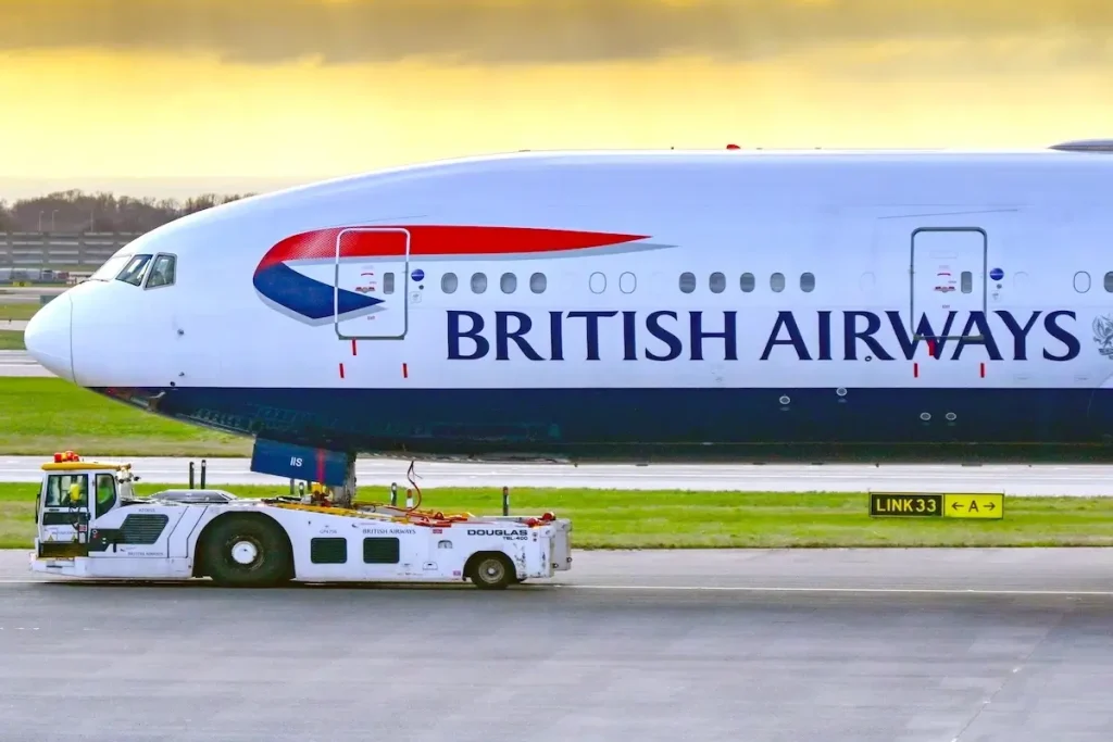 London, England, UK - 11 January 2024: British Aiways Boeing 777 being towed to the mainteance hangar by an aircraft tug