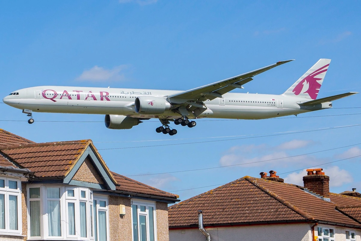 England/London March 12th 2019: A Qatar Airways Boeing 777 plane flies over residential houses as it approaches Southern runway before landing