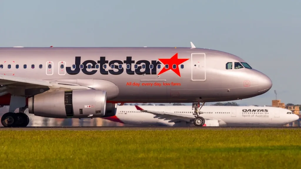 Sydney, Australia - May 5, 2014: Jetstar Airways Airbus A320 airliner landing at Sydney Airport with a Qantas aircraft in the background.