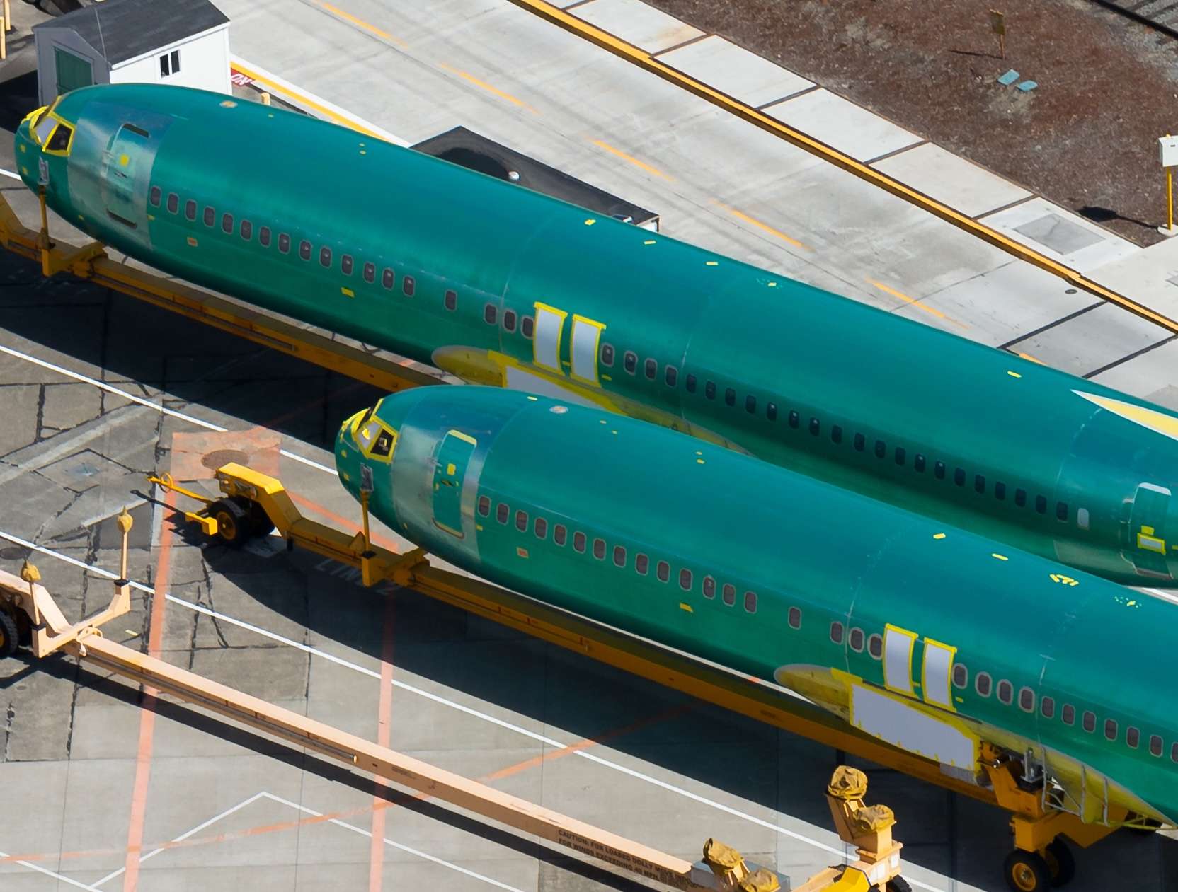 Pair of Boeing 737 (NG and MAX) fuselages wearing the protective anti corrosion green coat before entering the assembly line in Renton Airport facility