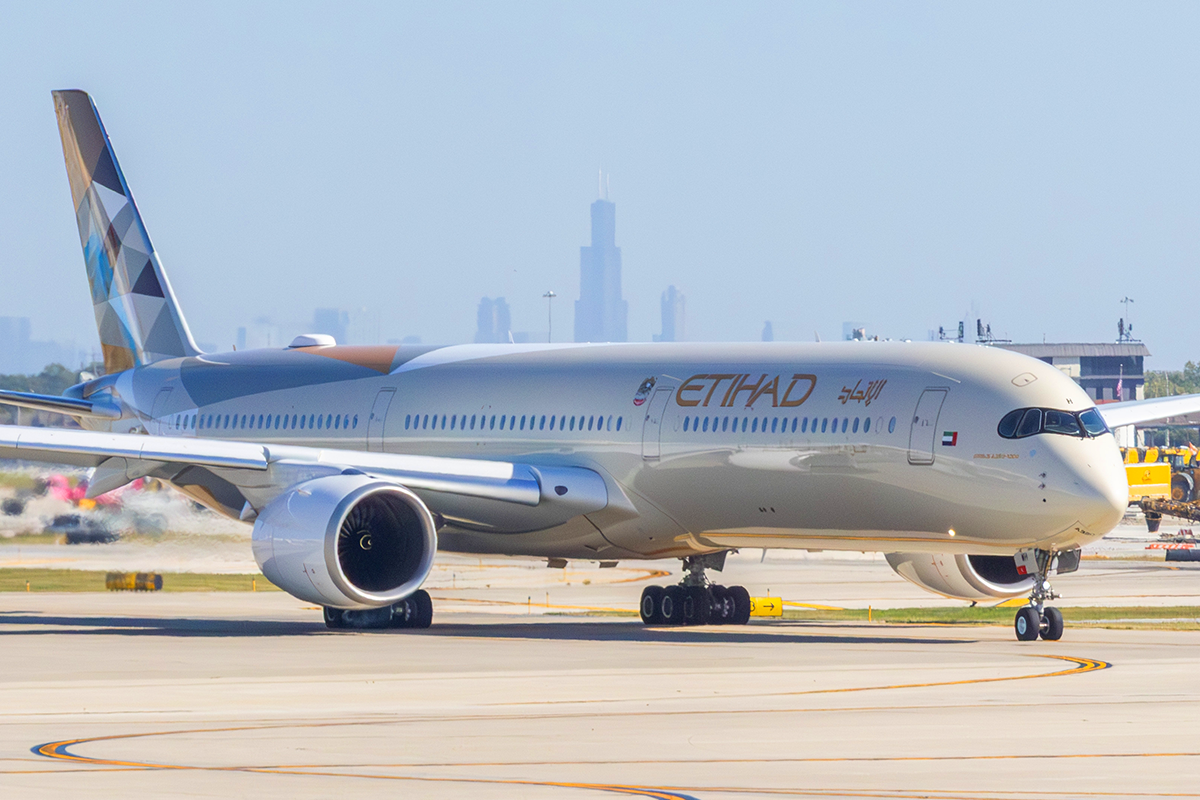 Etihad Airways Airbus A350 aircraft taxiing at OHare International Airport with Chicago downtown skyline visible in the distance