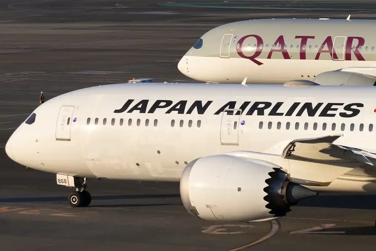 Japan Airlines Boeing 787-9 Dreamliner passenger airplane reg. JA868J taxiing past Qatar Airways Airbus A350-900 A7-AML