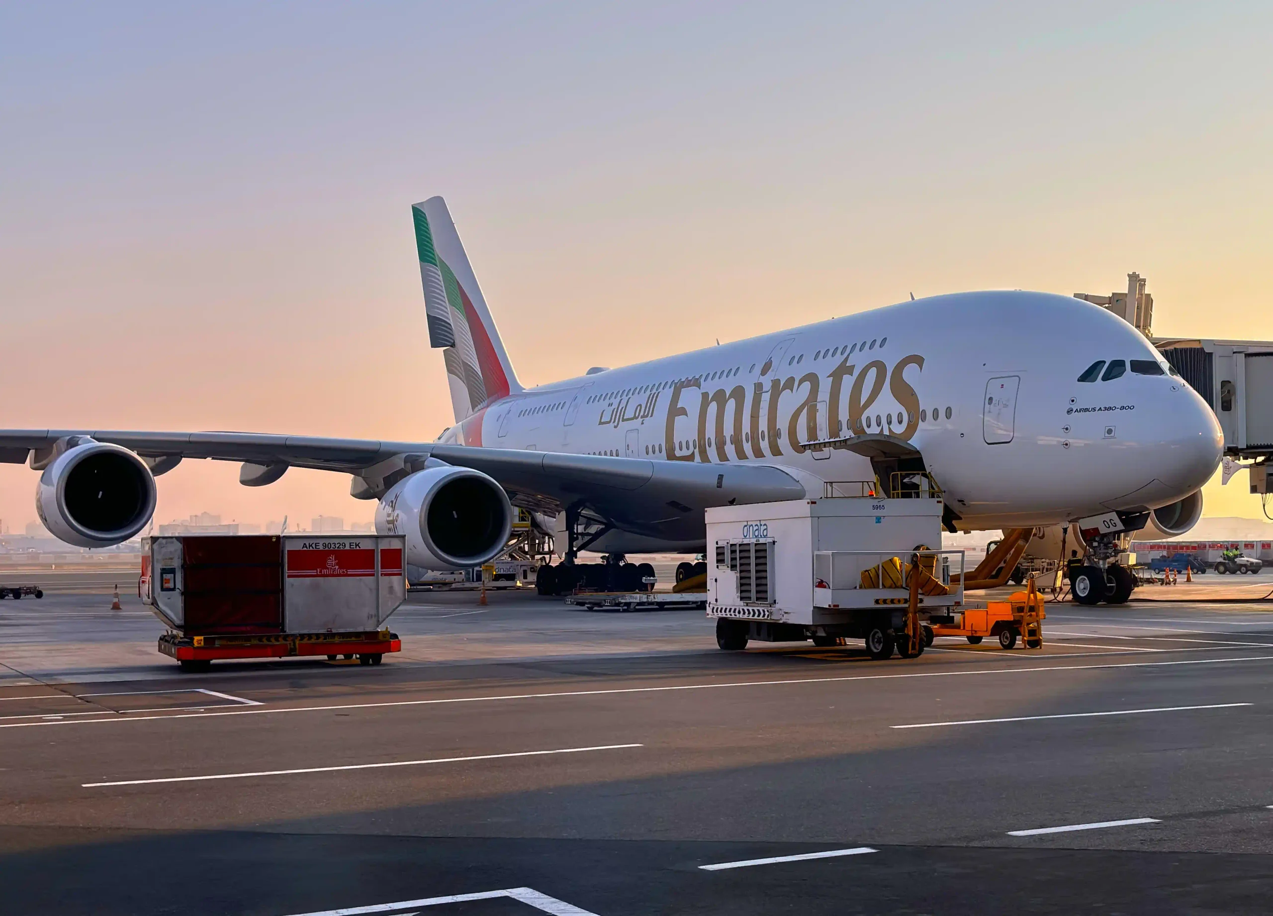 an Emirates Airbus A380 on tarmac at Dubai International Airport in the evening